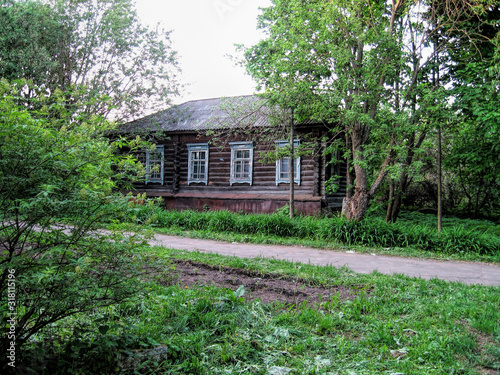 Road next to an old wooden house in summer in Russia
