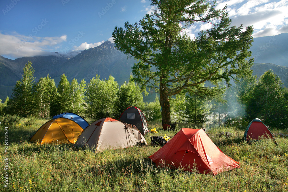 Tourist camp in the mountains. Morning light, green forests. Summer holidays in the mountains.
