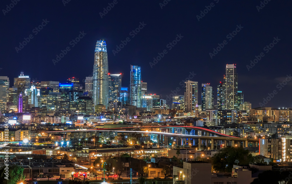 San Francisco skyline night view with city lights, the Bay Bridge and trail lights