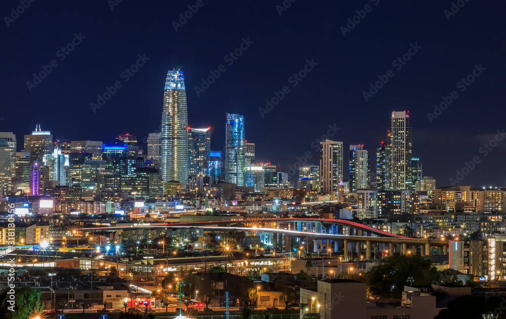 San Francisco skyline night view with city lights, the Bay Bridge and trail lights San Francisco skyline night view with city lights, the Bay Bridge and trail lights