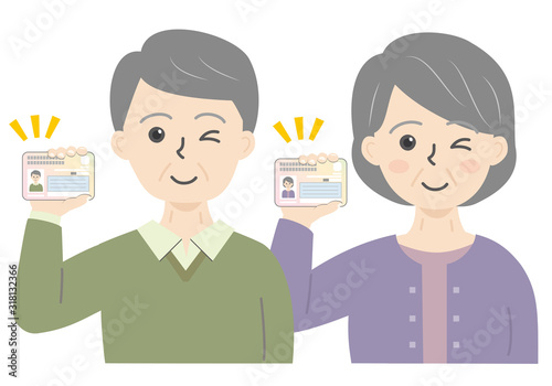 マイナンバーカードを持った高齢男女の上半身