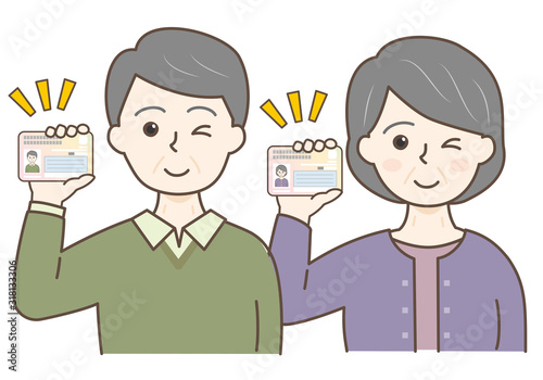 マイナンバーカードを持った高齢男女の上半身