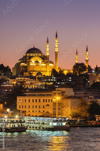 Suleymaniye Mosque and tourist boats at twilight in Istanbul, Turkey