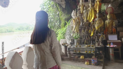 Woman Praying Buddha Statues In Tham Ting Cave , Slow Motion photo