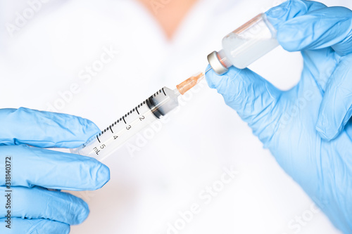 Doctor or nurse hand in blue gloves holing flu, measles vaccine shot, medicine and drug concept