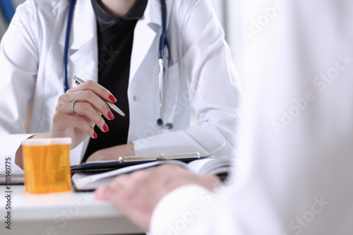 Fototapeta Naklejka Na Ścianę i Meble -  Female doctor hand hold silver pen filling patient history list at clipboard pad. Physical, exam, er, disease prevention, ward round visit check 911 prescribe remedy healthy lifestyle concept