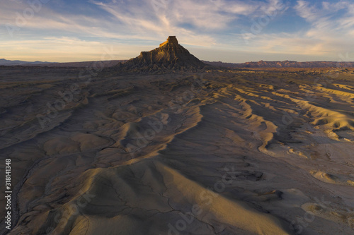 sunset over dramatic desert badlands texture with butte in distance