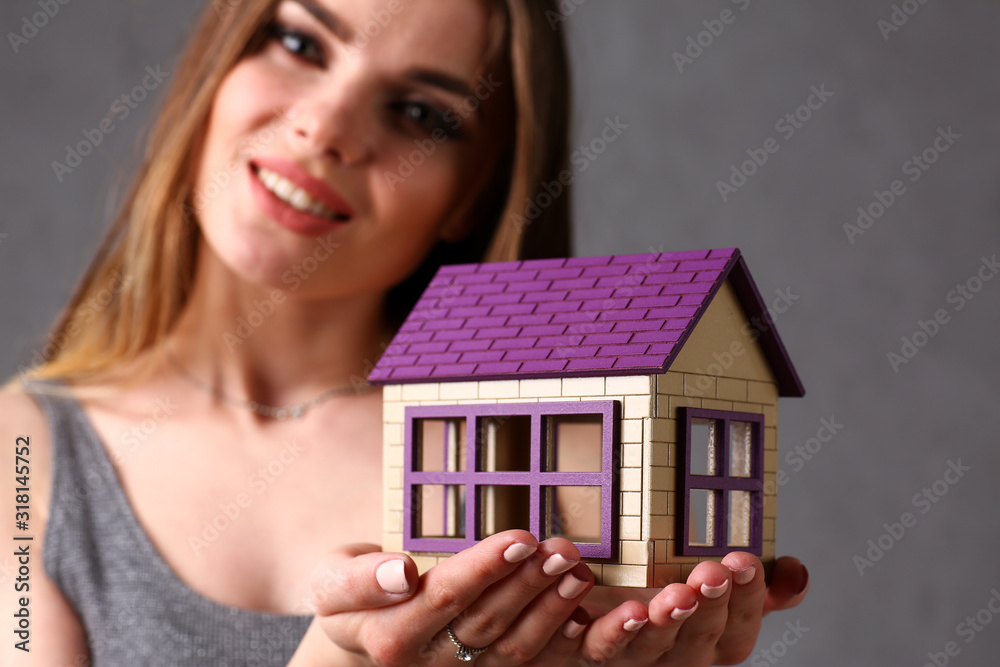 Beautiful european woman portrait. Holds a miniature toy doll house toy style curly hair with white locks eye view of the camera Beautiful european woman portrait. Holds a miniature toy doll house toy style curly hair with white locks eye view of the camera