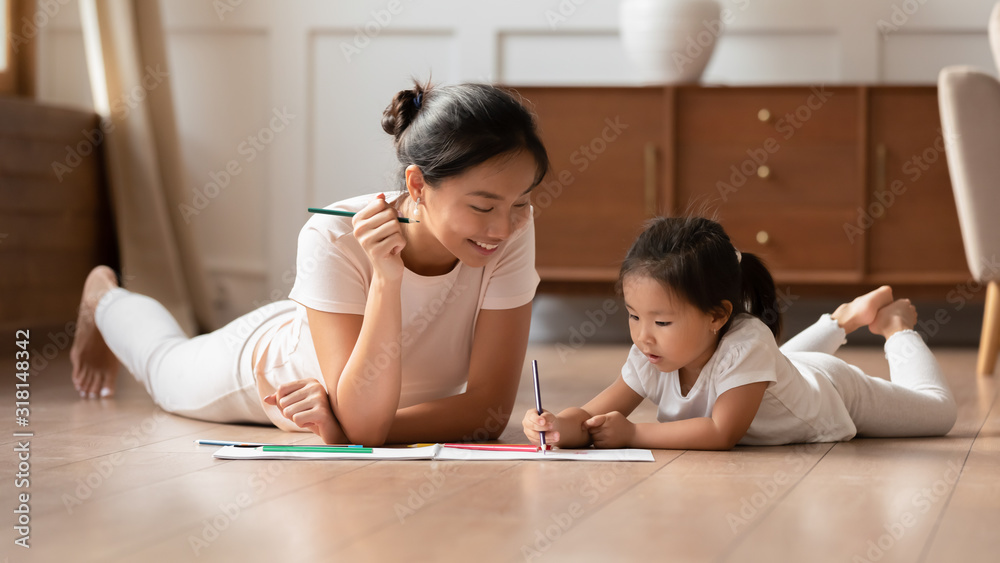 Young Vietnamese mom and little daughter painting at home - obrazy, fototapety, plakaty 