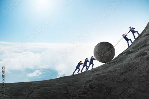 Bild auf Leinwand Teamwork example with business people pushing stone to top