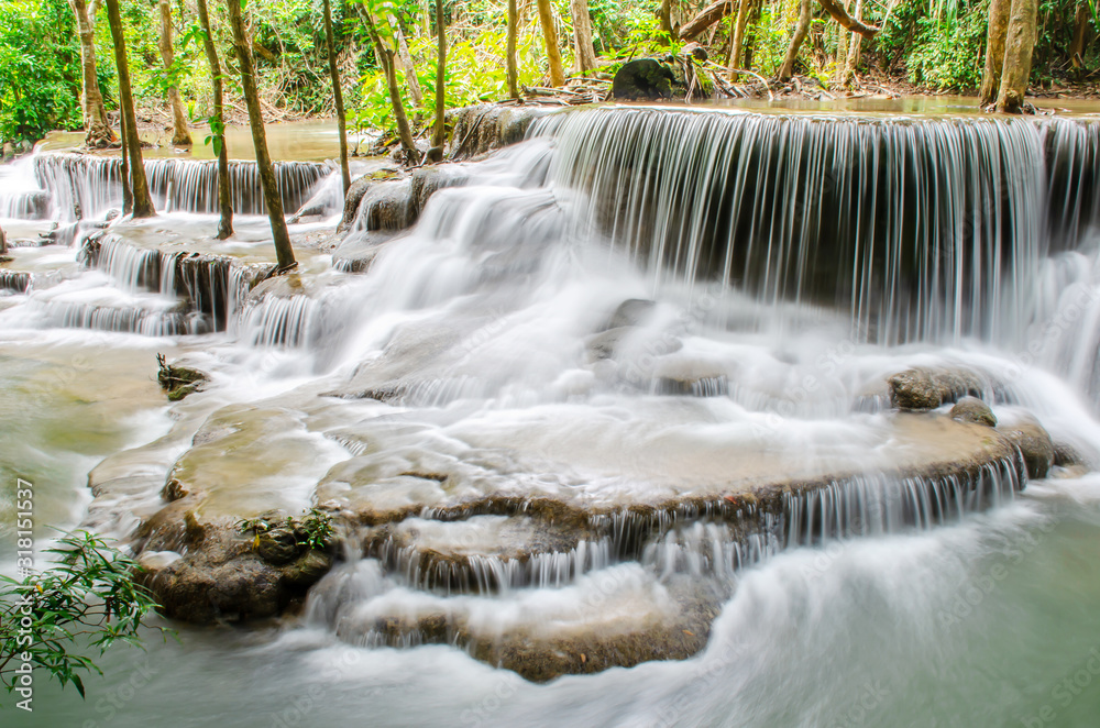 Obraz premium Travel to the beautiful waterfall in tropical rain forest, soft water of the stream in the natural park at Huai Mae Khamin Waterfall in Kanchanaburi, Thailand.
