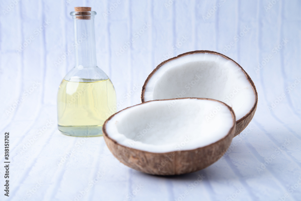 coconuts and Coconut oil in a bottle for cooking nutrition vegan ingredient natural put on a white table, Concept: alternative aromatherapy aromatic ingredient vitamin for therapy and massage coconuts and Coconut oil in a bottle for cooking nutrition vegan ingredient natural put on a white table, Concept: alternative aromatherapy aromatic ingredient vitamin for therapy and massage