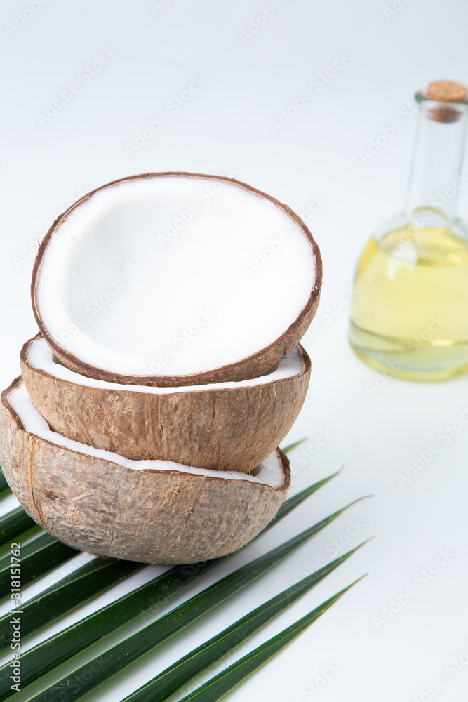 coconuts and Coconut oil in a bottle for cooking nutrition vegan ingredient natural put on a white table, Concept: alternative aromatherapy aromatic ingredient vitamin for therapy and massage coconuts and Coconut oil in a bottle for cooking nutrition vegan ingredient natural put on a white table, Concept: alternative aromatherapy aromatic ingredient vitamin for therapy and massage