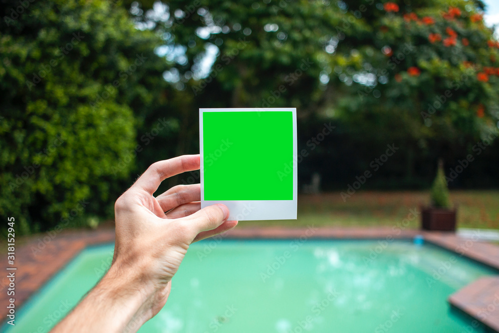 Holding Polaroid in front of swimming pool (landscape)