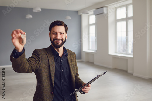 Realtor agent is a realtor with keys in hand against the background of a white real estate room apartment home. photo