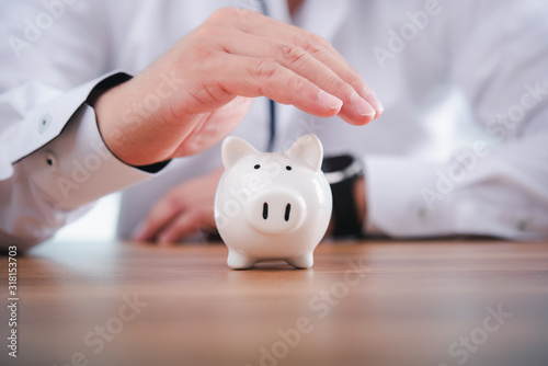 Businessman take a position to protect the piggy bank in hand.Concept of protection of business assets and finance.