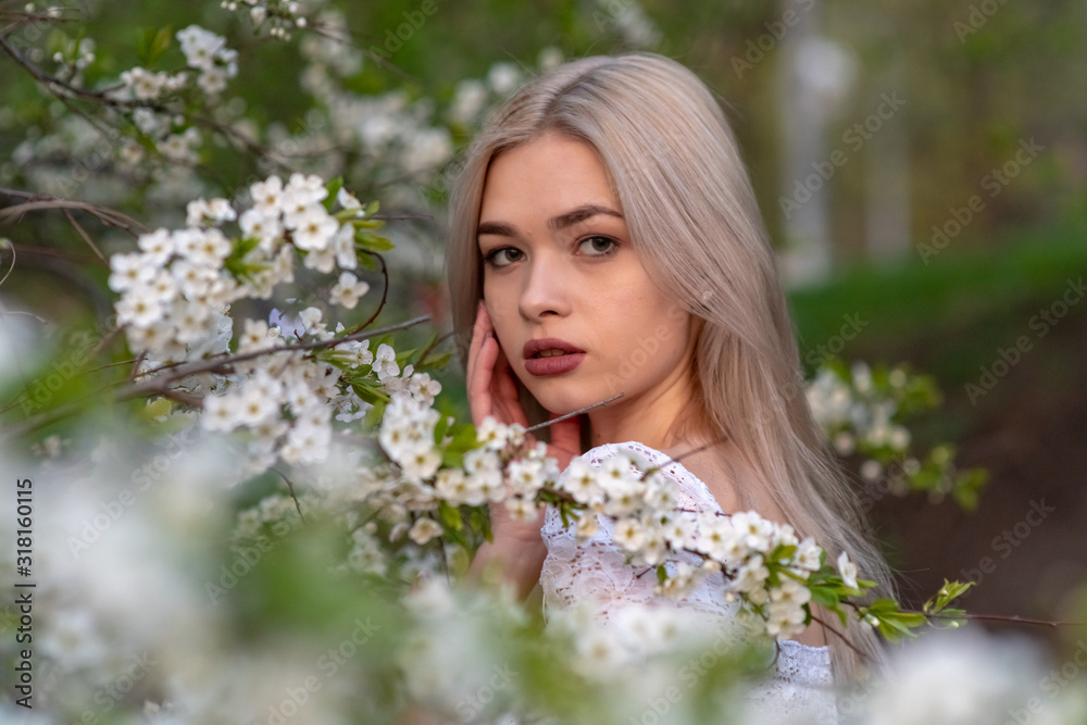 Fototapeta premium beautiful blonde girl in spring cherry garden