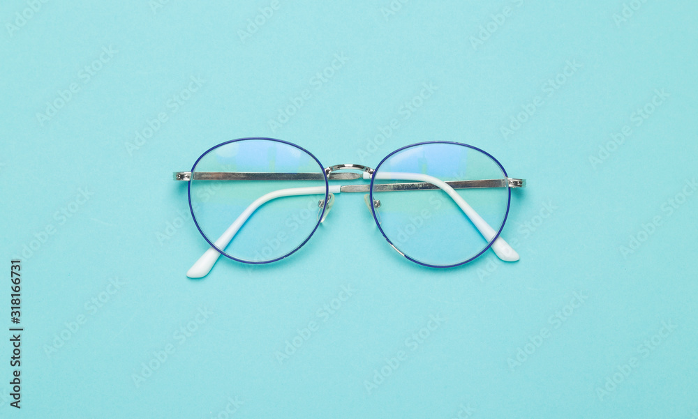 Eye glasses isolated on blue background. - obrazy, fototapety, plakaty 