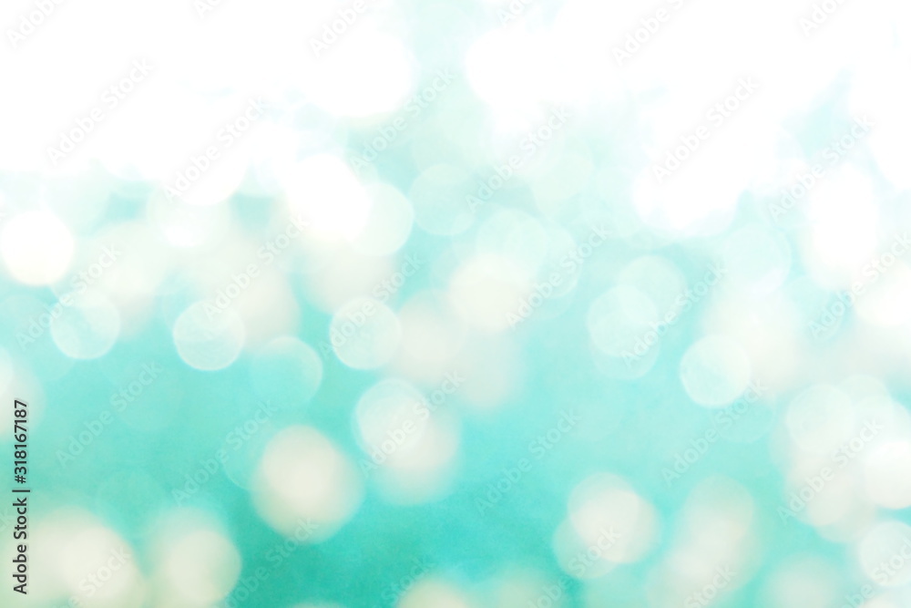 Obraz premium Beautiful abstract bokeh lights in green, turquoise and white tone for festive background and seasons greetings concept. Making glossy decoration and wallpaper