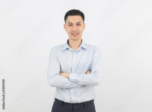 Young handsome asian business man looking to camera with arms crossed isolated on white background.