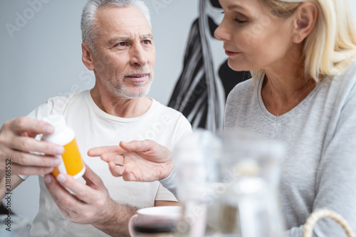 Curious couple discussing vitamins at the breakfast stock photo