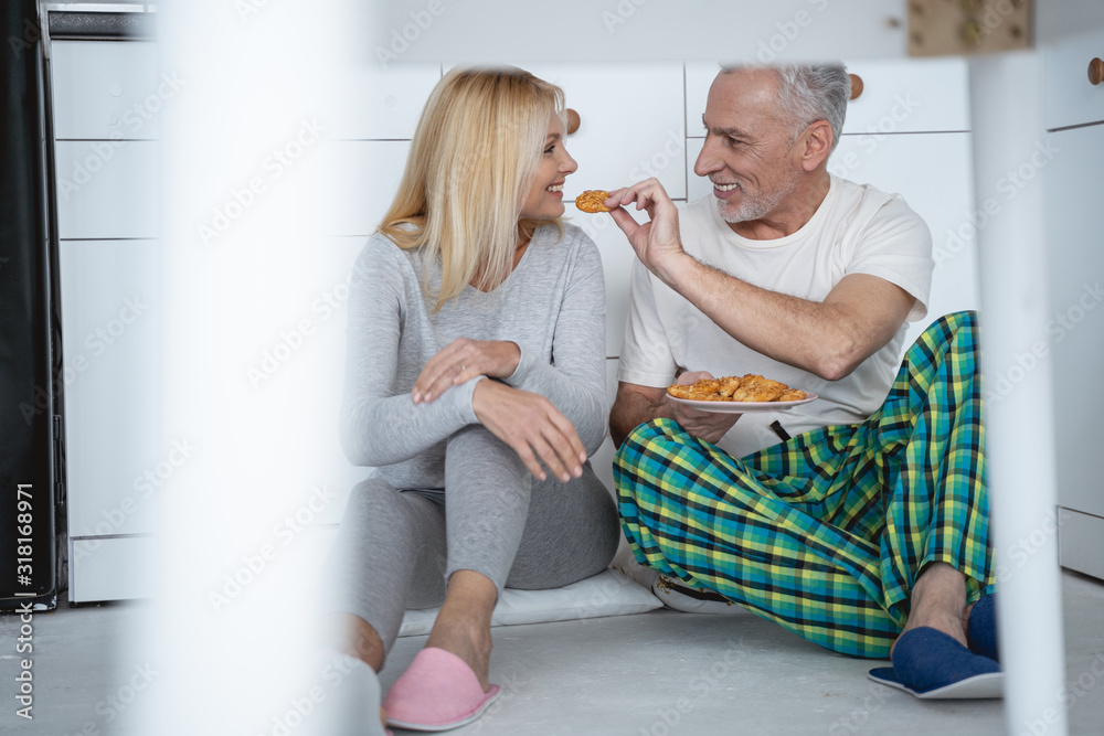 Happy man feeding his wife and smiling stock photo Happy man feeding his wife and smiling stock photo
