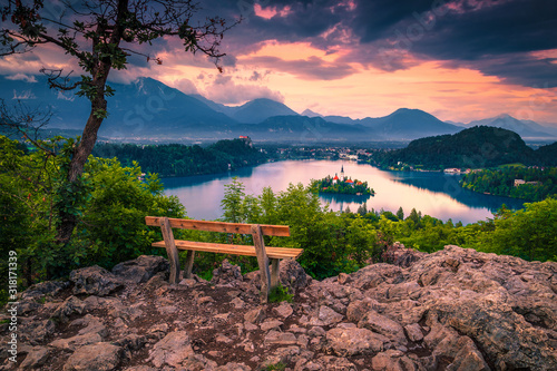 Fototapeta Naklejka Na Ścianę i Meble -  Wooden bench and beautiful view with lake Bled at sunset