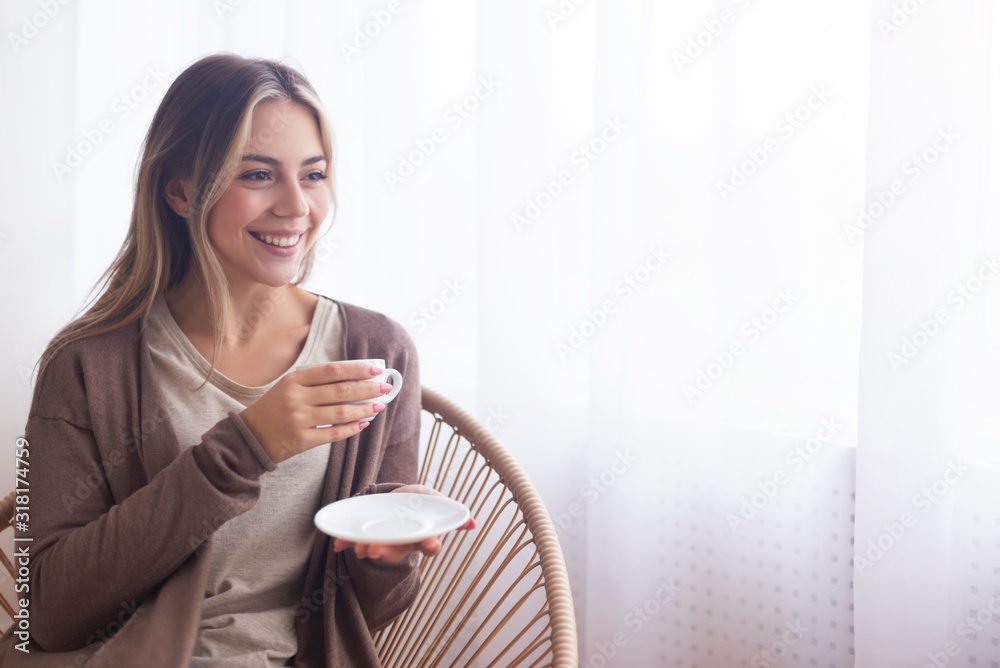 Cheerful girl enjoying favorite beverage at home Cheerful girl enjoying favorite beverage at home