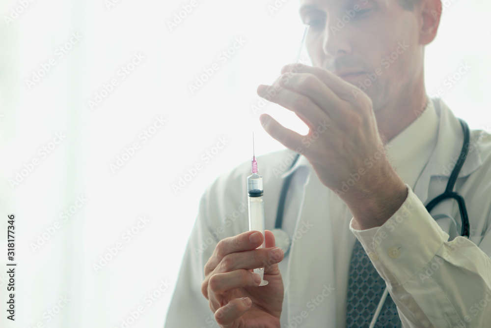 Doctor's hand holding syringe ready to make injection, health care and hospital concept Doctor's hand holding syringe ready to make injection, health care and hospital concept