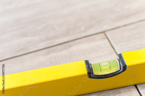 Close up shot of a metal yellow spirit level placed on a newly installed yet not finished kitchen tiles