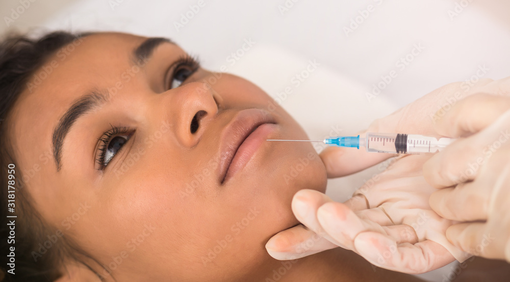 Beauty injection. Afro woman making lip augmentation procedure