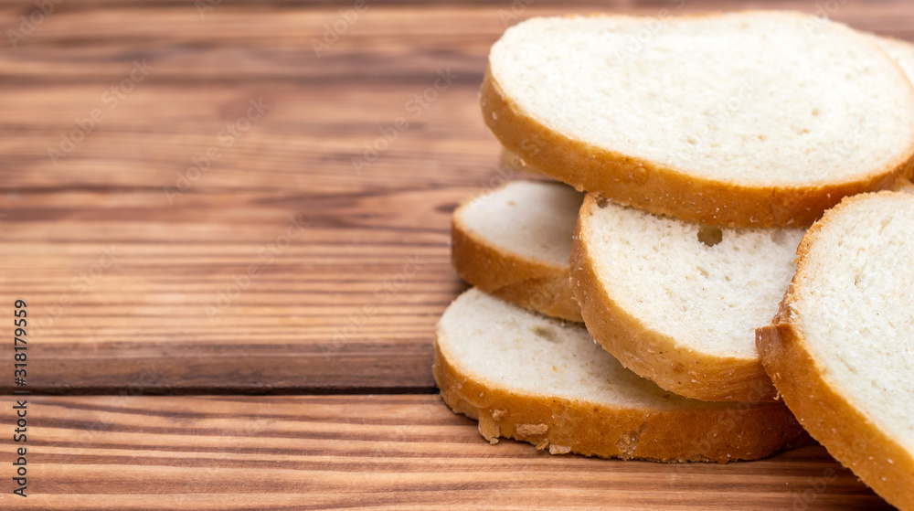 Heap of sliced bread on wooden background. CLose up. Space for text.