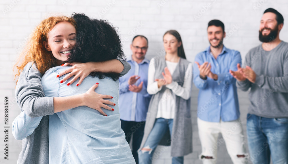 Happy people embracing each other after successful group meeting in rehab Happy people embracing each other after successful group meeting in rehab