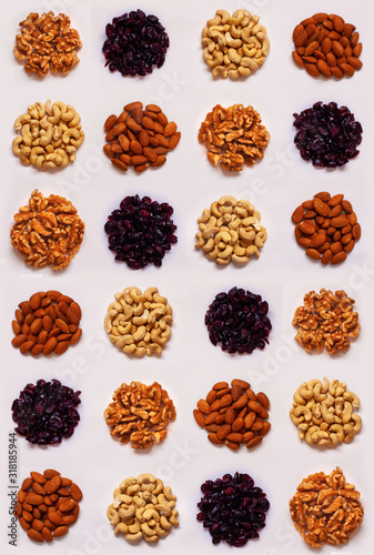 Seamless pattern of round dots of nuts (cashew, peanuts, almonds, walnuts), cranberry on light background.