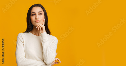 Pensive Brunette Girl Touching Her Chin, Thinking About Something
