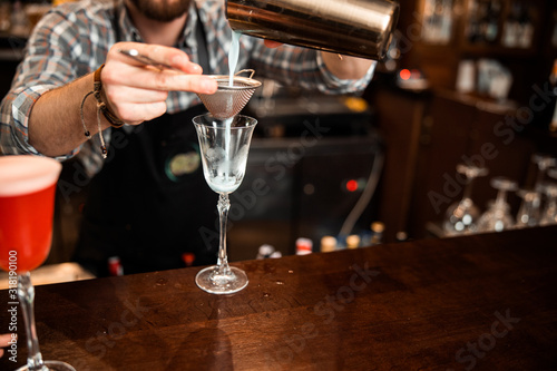 Cropped photo of barman using a sieve and shaker