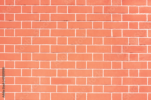 Orange brick wall. Light red background of masonry. Texture stained blocks of stonework. Plastered facade of building.