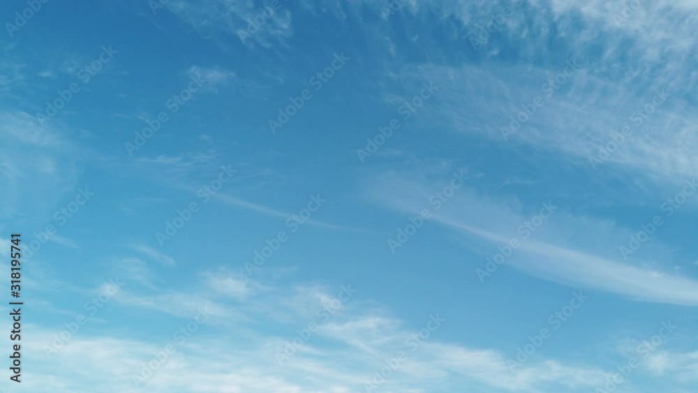 Fluffy threads of white cirrus clouds move slowly across a blue sky, a beautiful relaxing timelapse abstract background Fluffy threads of white cirrus clouds move slowly across a blue sky, a beautiful relaxing timelapse abstract background
