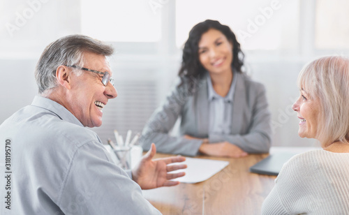 Mature couple consulting with financial adviser at home
