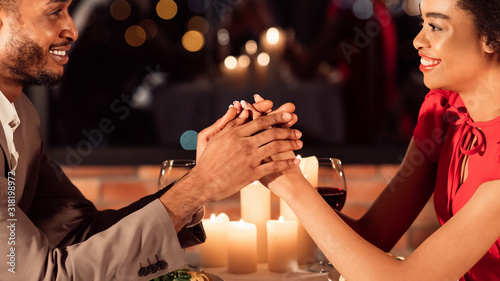 Couple On Romantic Date Holding Hands Smiling Sitting In Restaurant