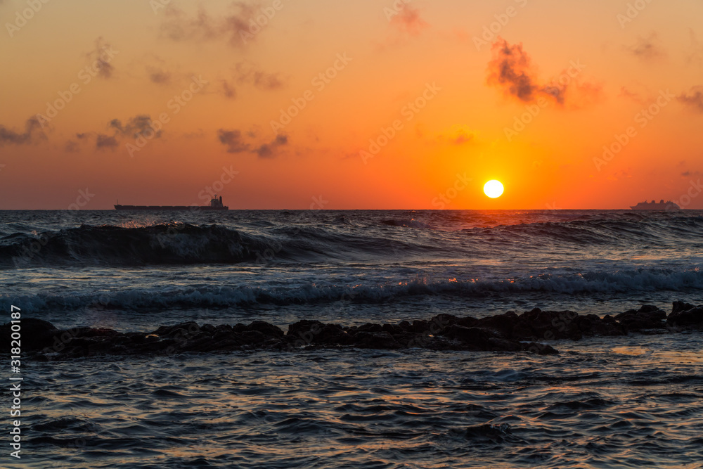 Beautiful sunset with the gold sun disk and red clouds is on the ocean beach Beautiful sunset with the gold sun disk and red clouds is on the ocean beach
