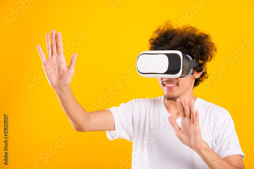 Asian handsome man with curly hair he using virtual reality headset or VR glass