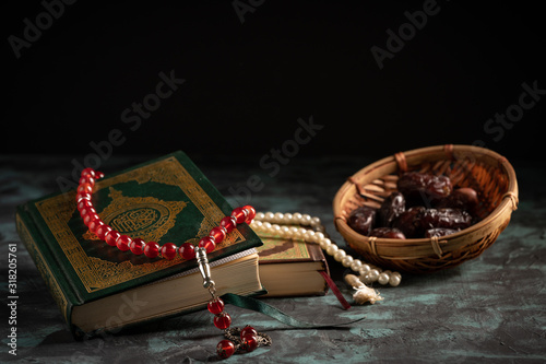 Islamic concept: The holy Quran and Tasbih (rosary beads) on dark background