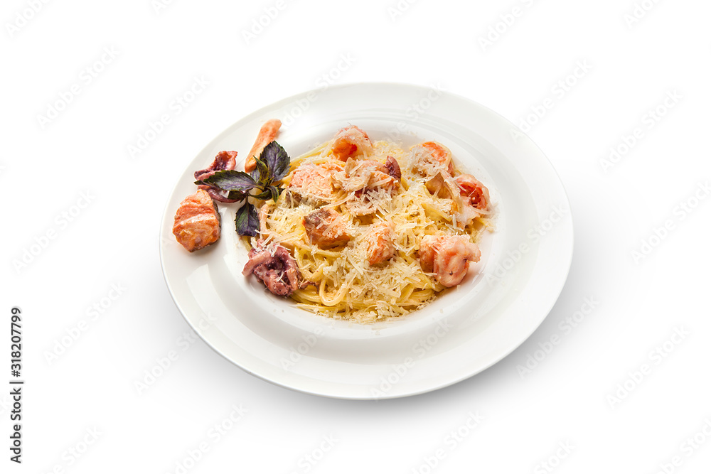 Spaghetti with shrimp, octopus, scallops and basil. Pasta with seafood on a white plate on a white isolated background.