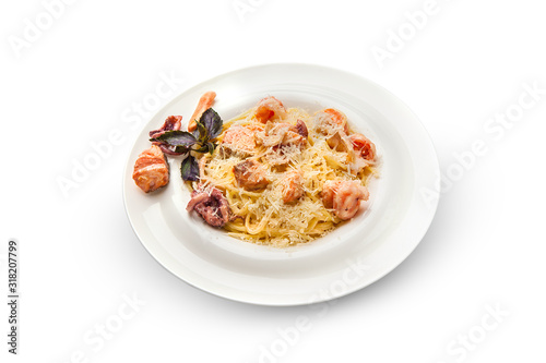 Spaghetti with shrimp, octopus, scallops and basil. Pasta with seafood on a white plate on a white isolated background.