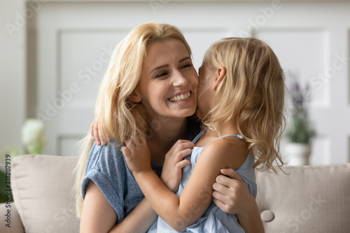 Joyful young mother playing with small daughter.