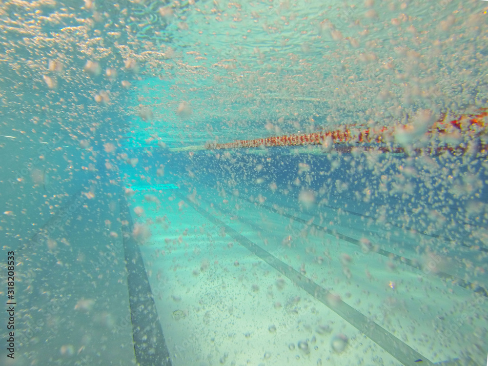 Indoor swimming 25 meter pool. View under water. Sports track. Venue for water sports and competitions. Artificial reservoir. Water purification in the sports complex. Air bubbles in the fluid Indoor swimming 25 meter pool. View under water. Sports track. Venue for water sports and competitions. Artificial reservoir. Water purification in the sports complex. Air bubbles in the fluid