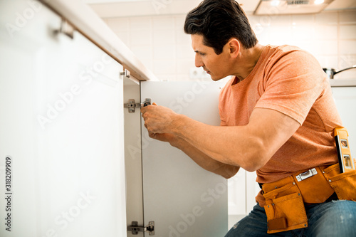 Adult man is repairing furniture at home