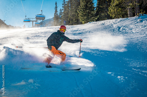 Snow cloud produced by aggressive braking from a young skier photo