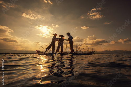 Intha Burmese fishermen on boat catching fish traditional at Inle Lake, Shan State, Myanmar photo